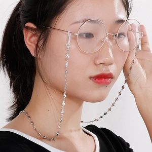 Chaîne à lunettes coeur en acier titane argenté portée par un mannequin sur fond blanc