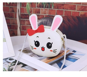 Detail of cute white rabbit shoulder bag with pink ears and red bow for kids