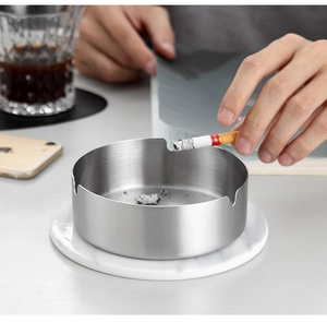 Close-up of a silver brushed stainless steel ashtray on a minimalist business desk