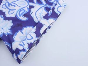Détail du tissu à imprimé floral bleu montrant les coutures et la finition de l'ourlet