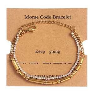 Macro detail of double-layered gold Morse Code bracelet with sparkling rhinestones and beads