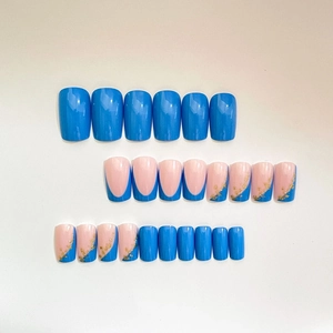 Short blue press-on nail set featuring solid colors, French tips, and gold foil accents