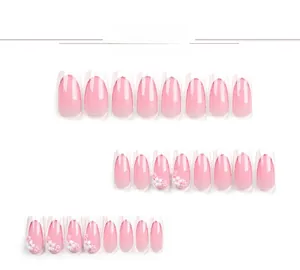 Detail view of pink gradient coffin press-on nails with 3D white flowers and glitter