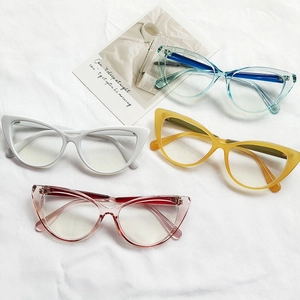 Collection of cat-eye glasses frames in blue, white, yellow, and pink colors on fabric