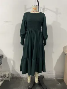 Detail of smocked elastic ruffles on the sleeves and waist of a dark green dress