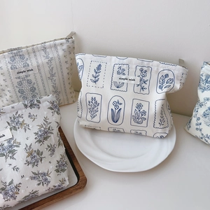 Detail of floral cotton pouches with zipper and simple wish label on a white dish