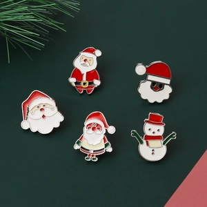 Detailed close-up of 5-piece enamel Christmas lapel pins with Santa and snowman on green card