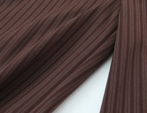 Detailed view of dark brown fabric with fine white vertical stripes and soft texture