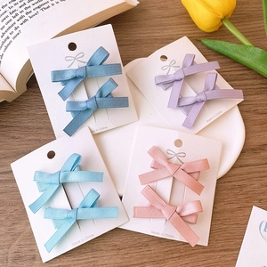 Detail of colorful grosgrain ribbon bow hair clips on display cards in balletcore style