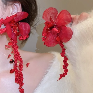 Detailed view of red floral fabric earrings with sparkling sequins and ribbon tassels