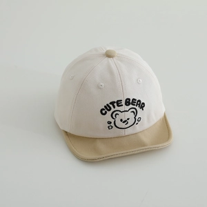 Detailed close-up of cute bear embroidery on a canvas baby baseball cap with khaki brim