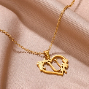 Dettaglio della collana con pendente a cuore dorato con lettera U e motivi floreali