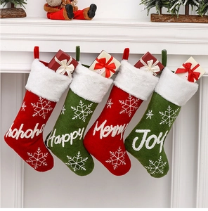 Close-up of four festive Christmas stockings with embroidered holiday greetings on a white mantel