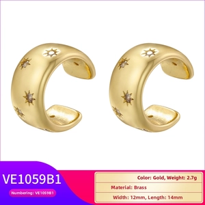 Detailed view of gold C-shape ear cuff with star pattern engraving and brass texture
