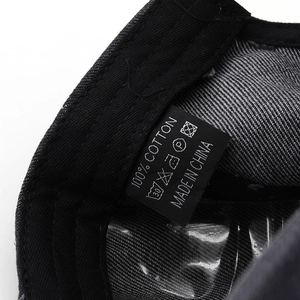 Detail view of cotton baseball cap interior featuring a high-quality woven washing label