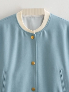 Detail of light blue bomber jacket with ribbed collar and golden snap buttons