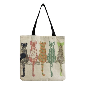 Cute canvas tote bag with five colorful patterned cats sitting and black handles