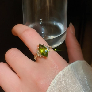 Close-up of 14K gold plated ring featuring a green marquise emerald and side diamonds