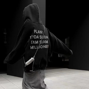 Detail of loose-fit black hoodie featuring silver artistic text print on the back