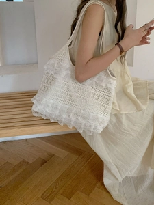 Detailed close-up of intricate lace crochet layers and ruffled edges on the beige tote bag