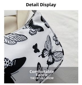 Detailed close-up of woven canvas texture with black butterfly print on white shoulder bag