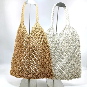 Detail of handmade woven cotton rope bags in khaki and cream white hollow mesh design