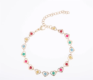 Détail d'un bracelet doré 18K avec breloques cœurs colorés en émail et chaîne d'extension réglable