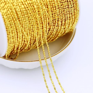Detailed view of 18K gold plated copper beaded chain wrapped on a white spool for DIY jewelry
