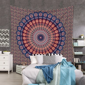 Detailed view of bohemian mandala tapestry featuring blue and orange patterns on a bedroom wall