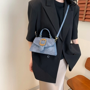 Chic light blue crossbody bag with gold buckle shown on professional model outfit