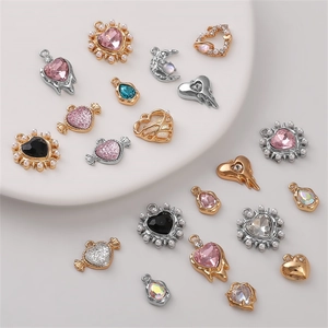 Macro display of alloy heart and flower charms for DIY jewelry and necklaces