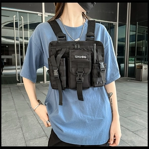 Detail view of adjustable straps and multiple pockets on black tactical chest bag