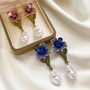 Détails de boucles d'oreilles vintage fleurs avec cristaux et perles baroques sur soie