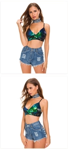 Detail of high-waisted distressed denim shorts with fringe and sequined gradient crop top