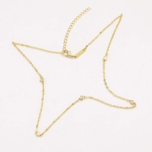 Detailed shot of a gold choker chain with five round cubic zirconia and adjustable clasp