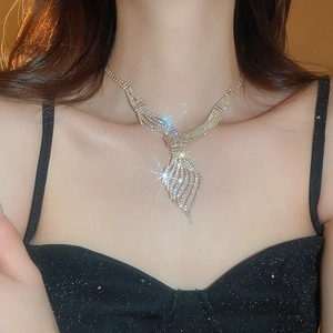 Detail of gold leaf necklace with sparkling crystals on model in soft lighting