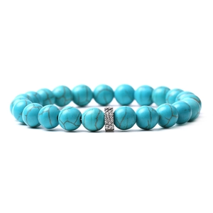Detail showing turquoise-style beads with a silver textured metal cylinder spacer charm