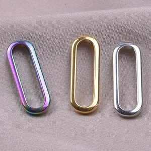 Macro detail of oval stainless steel rings in rainbow, gold, and silver finishes