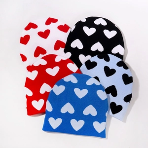 Berretti in maglia con motivi a cuore in vari colori su uno sfondo bianco pulito