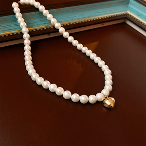 Collier de perles vintage français avec un pendentif coeur doré sur fond en cuir