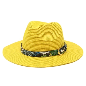 Detail of yellow straw sun hat with snake print band and golden buckle finish