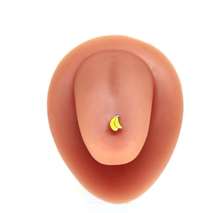 Detailed close-up of a yellow banana tongue ring on a model with a metallic finish
