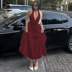 Detailansicht dunkelrotes Neckholder-Kleid mit tiefem V-Ausschnitt und weitem Rocksaum