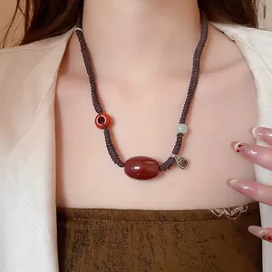 Vintage agate necklace with hand-woven wax rope and engraved silver pendant on a model