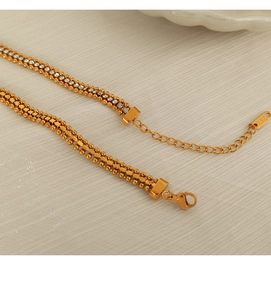 Macro shot of 18K gold-plated chain bracelet featuring rows of white crystals and lobster clasp