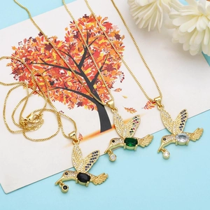 Detailed view of hummingbird pendants with colorful pavé crystals on gold box chains