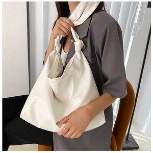 Chic cream white PU leather tote bag shown on shoulder with minimalist styling and soft texture