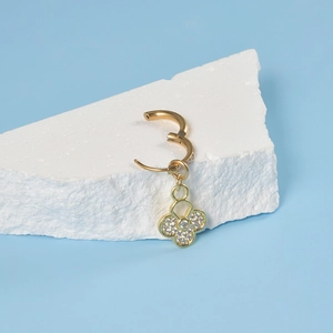Detail of 18K gold huggie earring with sparkling clover pendant and pavé set zircons