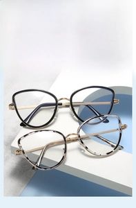 Detail of cat-eye metal glasses frames in black and tortoise finish on a display