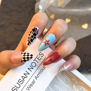 Detail of almond-shaped press-on nails with leopard print, checkerboard and star patterns